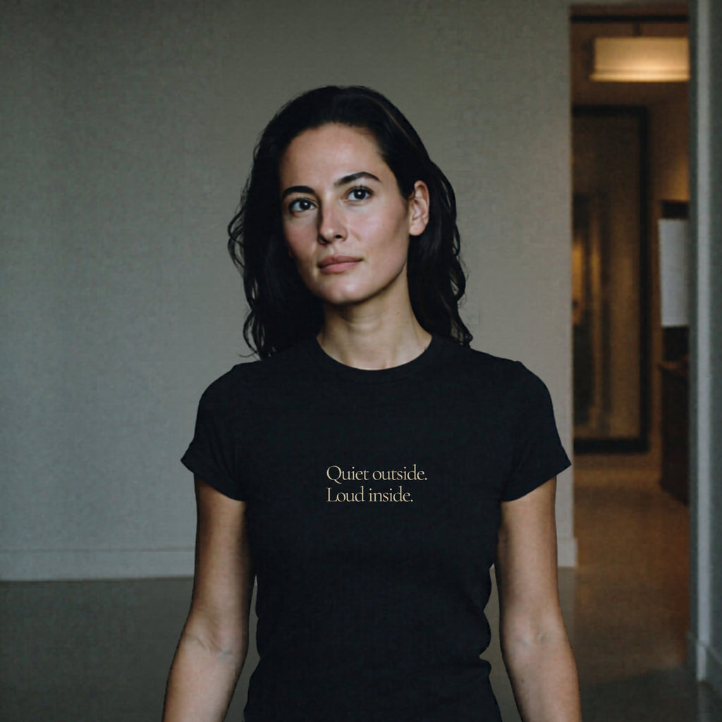 Woman wearing Question Everything Co. black t-shirt in hallway saying Quiet outside. Loud inside.