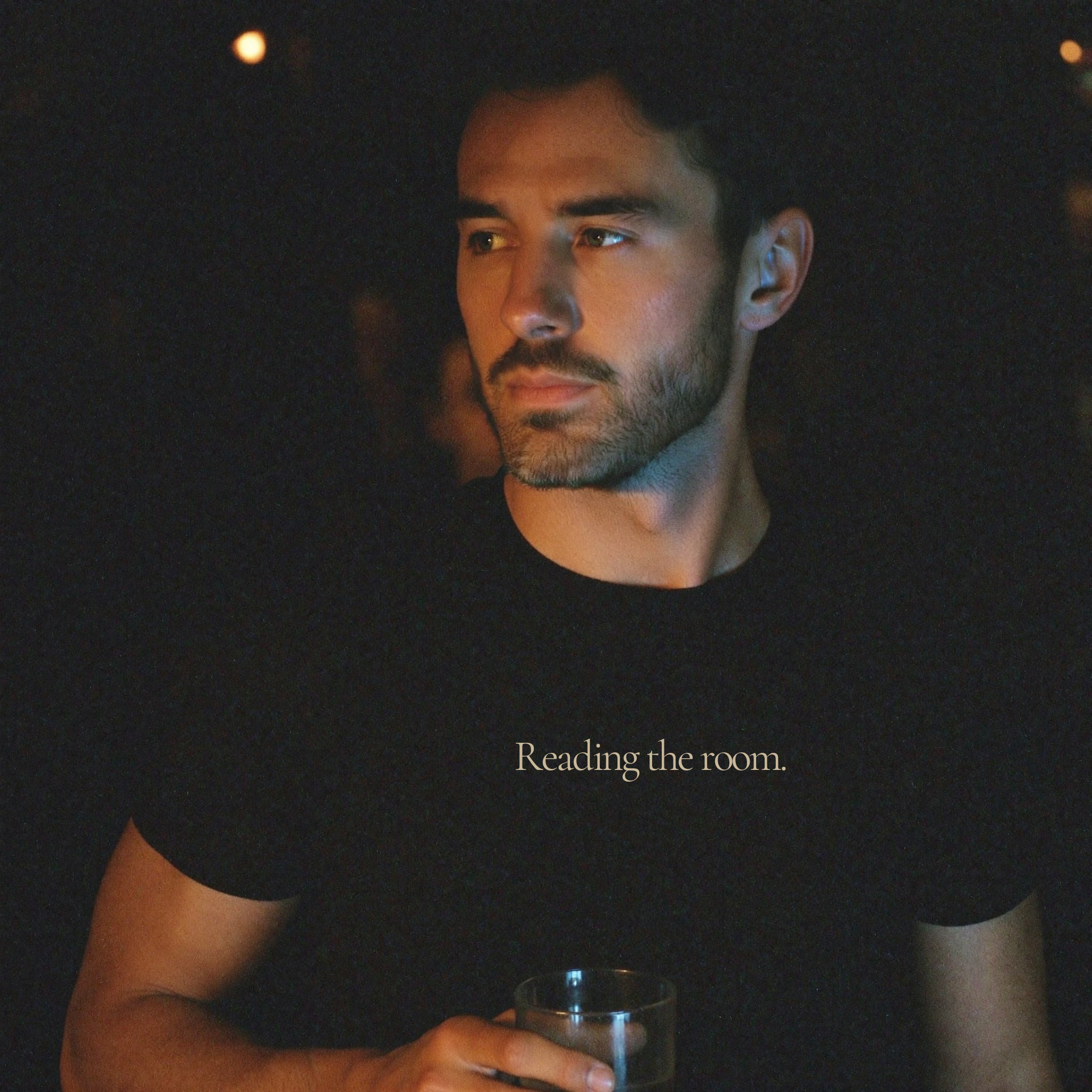 man wearing question everything co. black tee reading the room