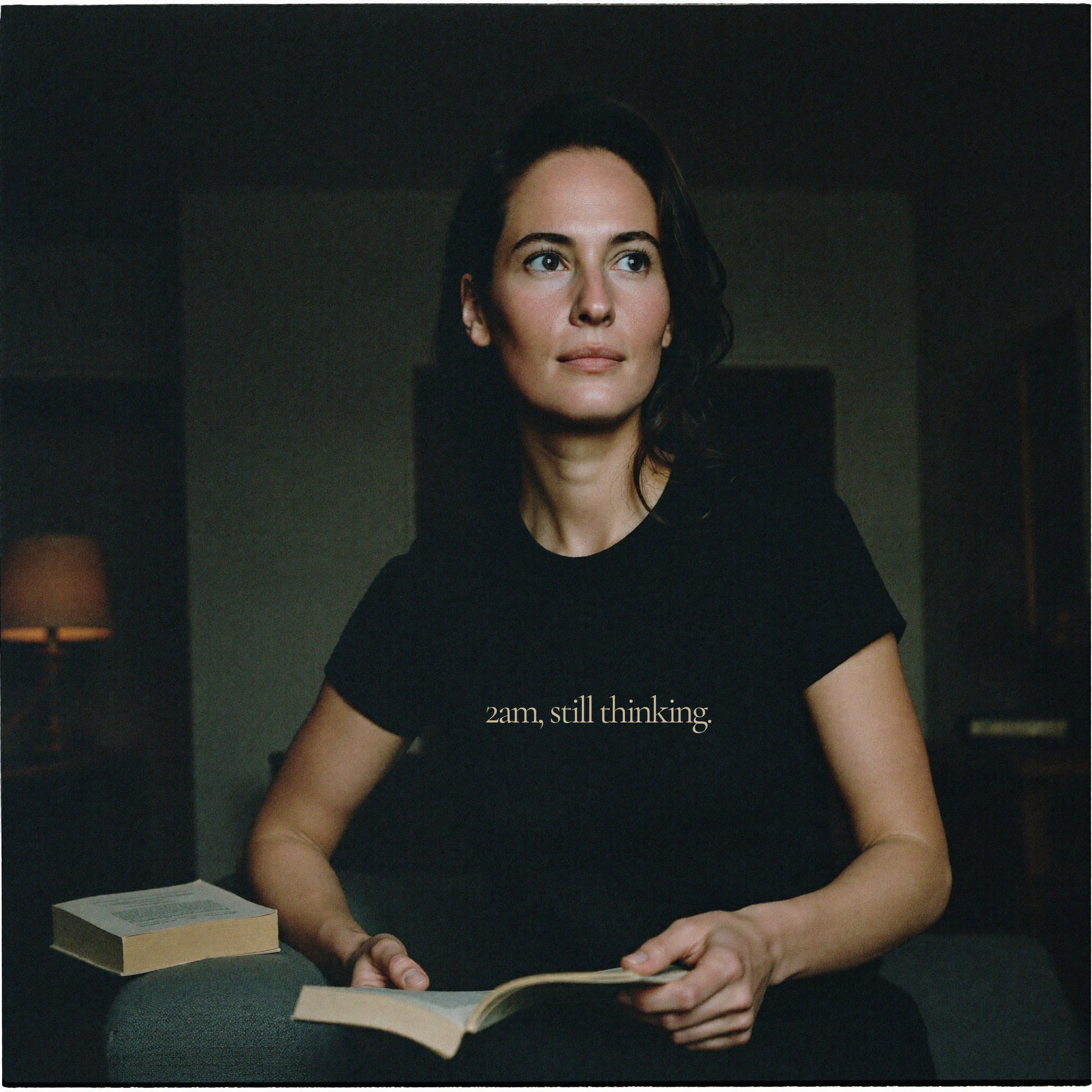 Woman wearing Question Everything Co black tee reading 2am, still thinking, dark study