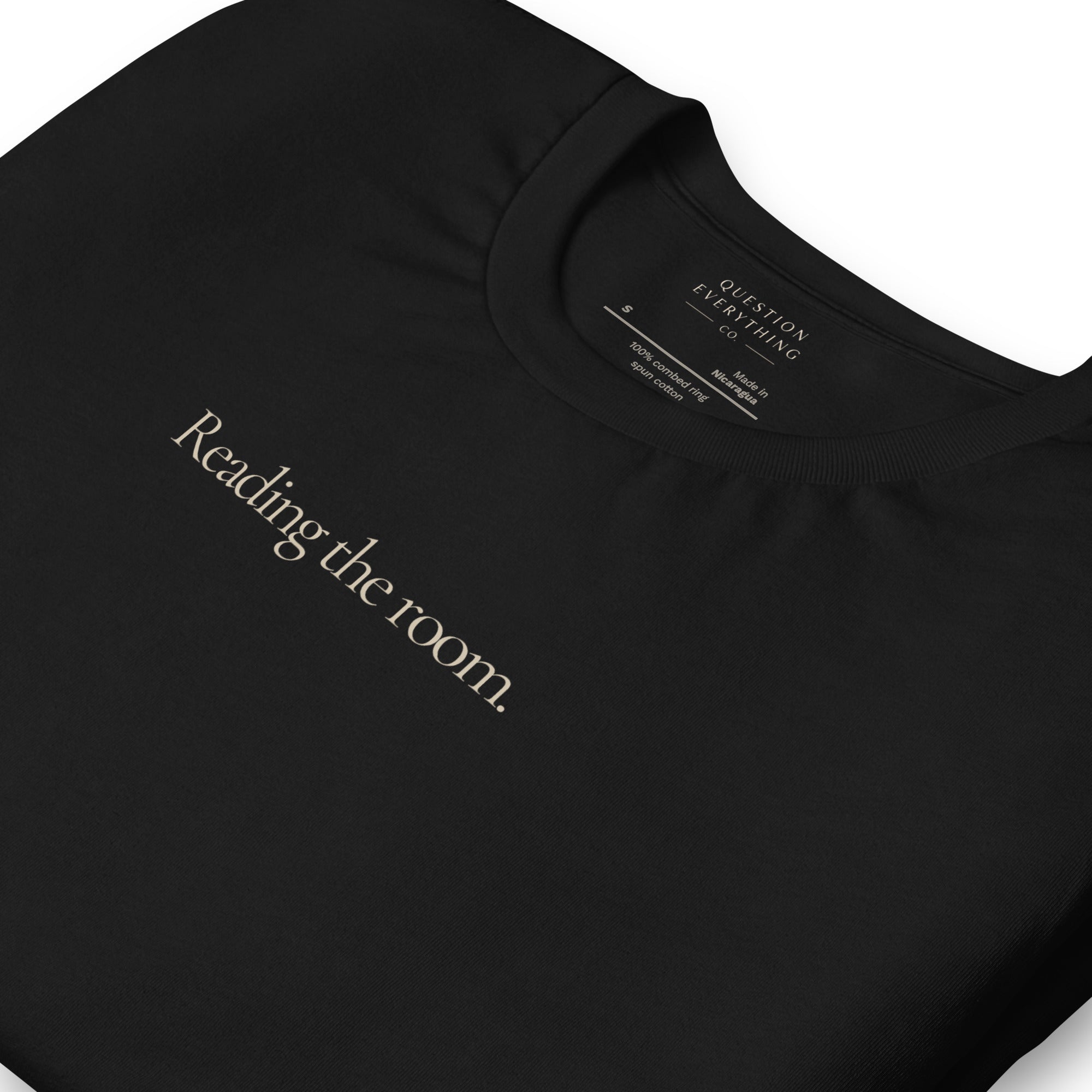 Reading the room. black t-shirt folded with inside label shown.
